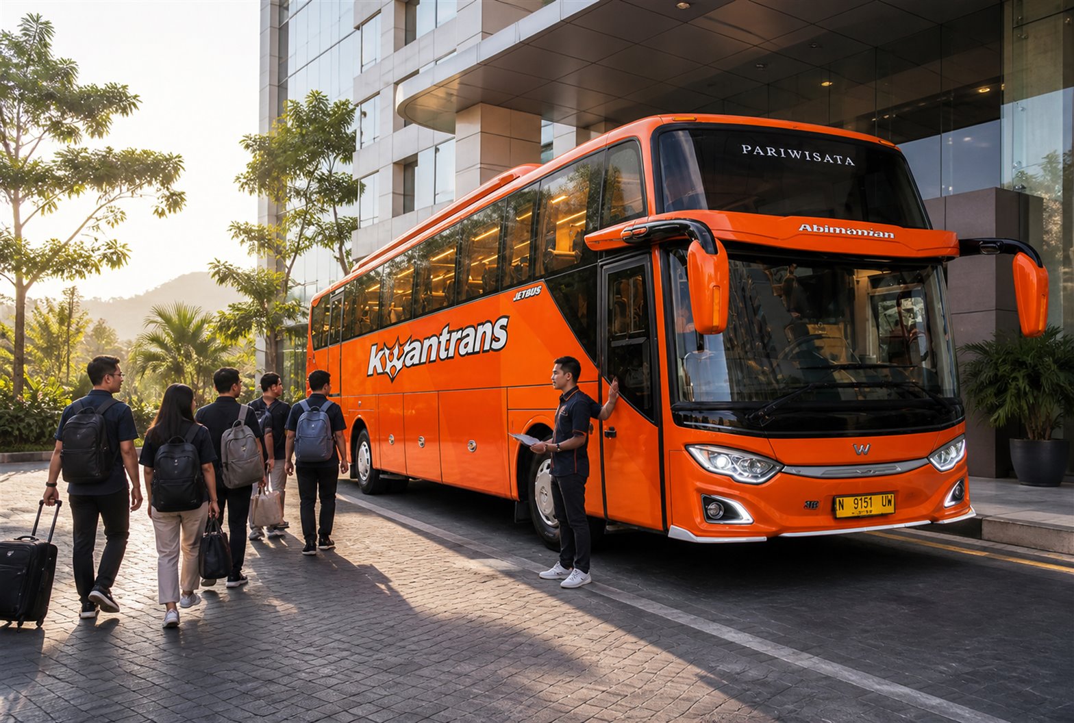 Karyawan berkaos grup berfoto bersama di depan bus Sewa Bus Malang untuk gathering kantor